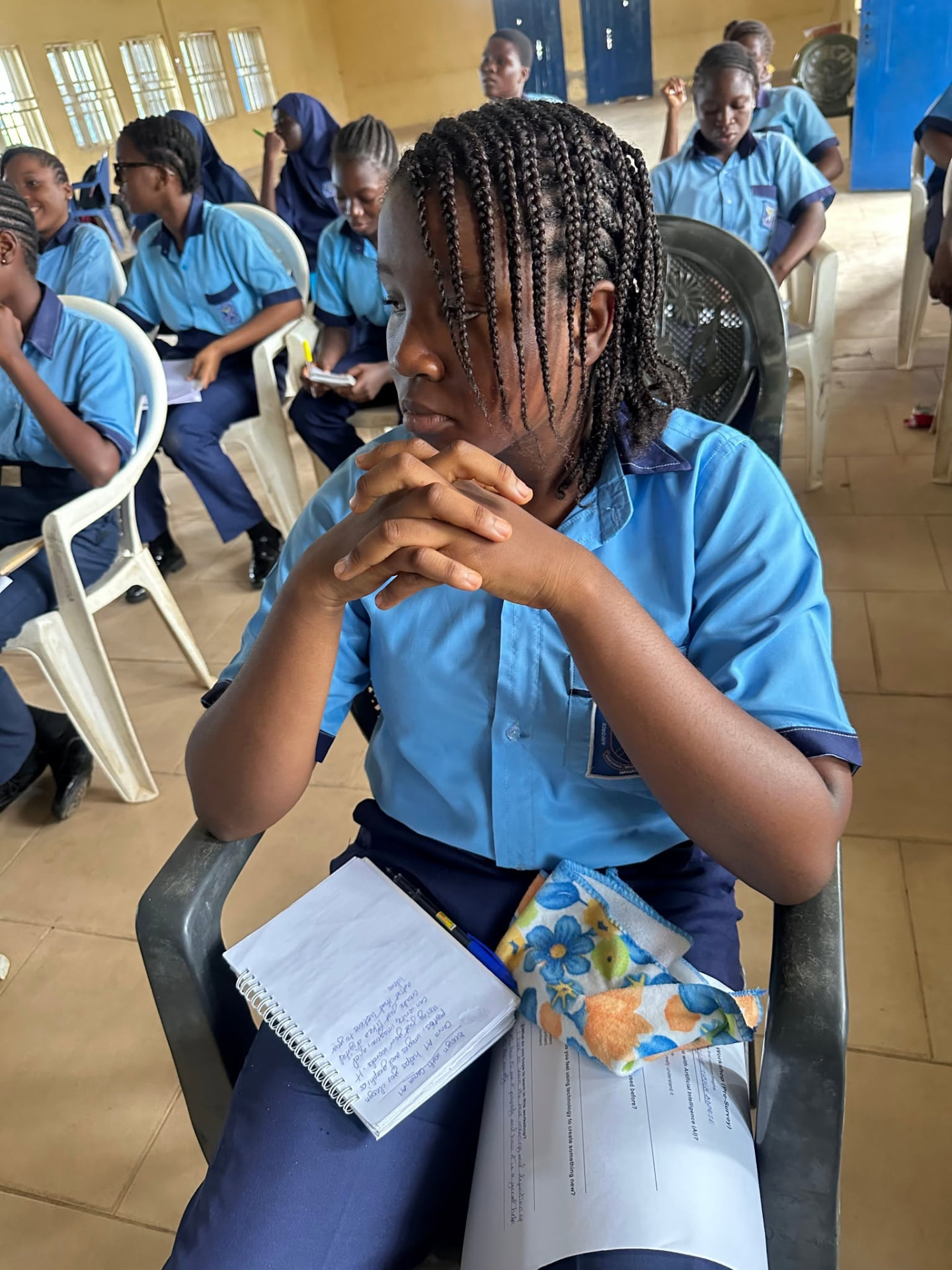 A student rests her chin on her hands, listening intently