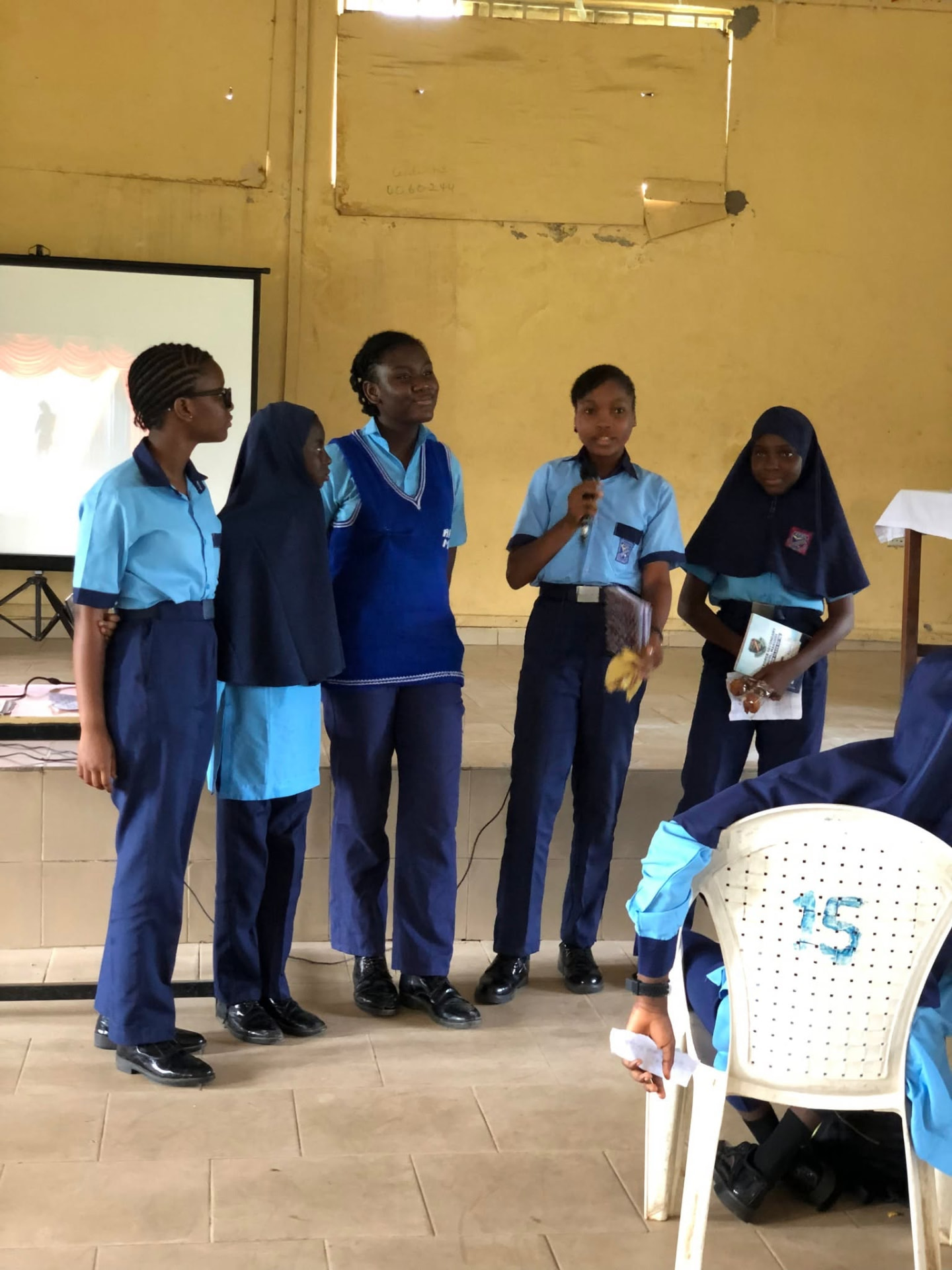 Five students on stage presenting their group work
