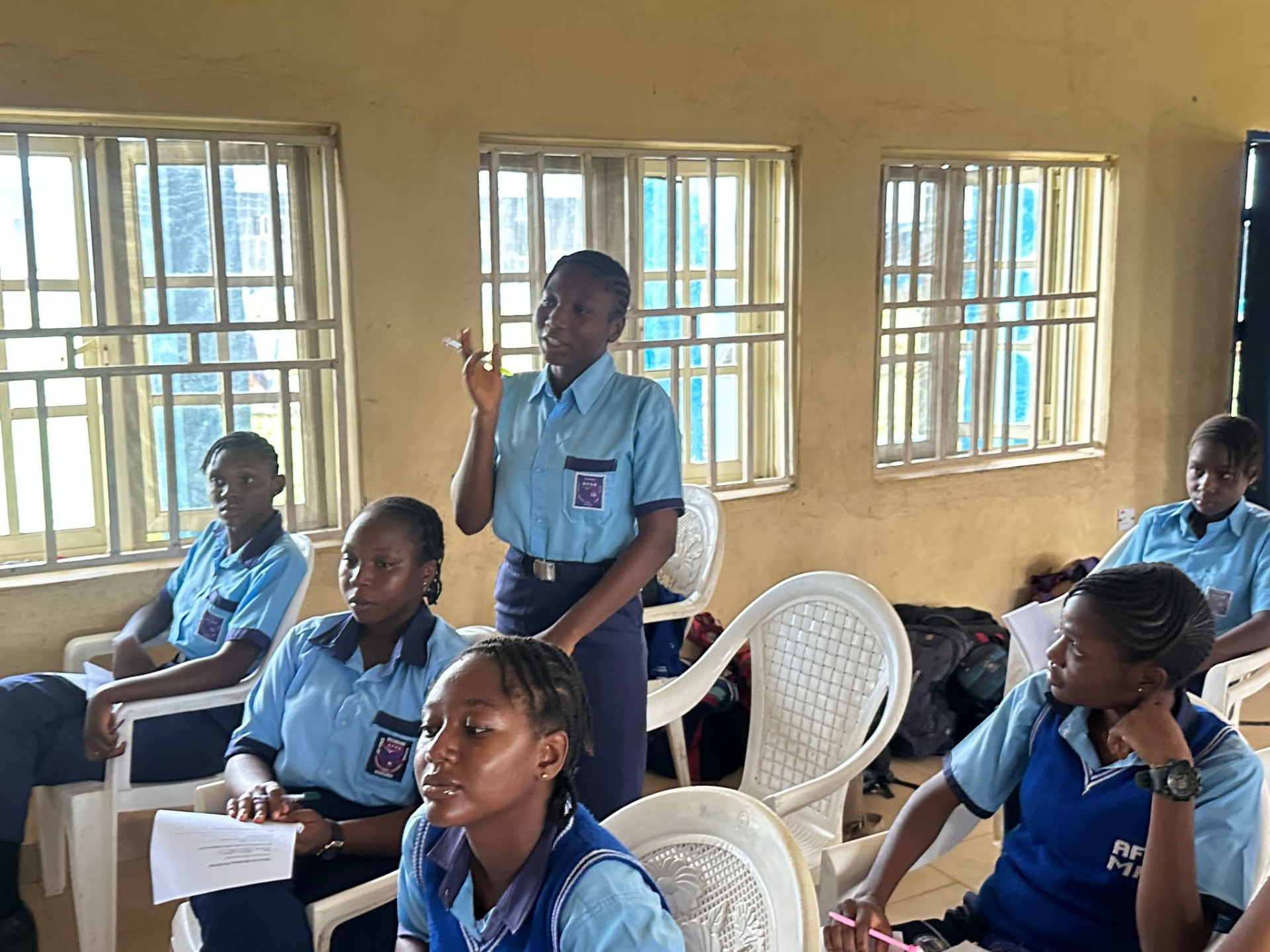 A student stands to share her answer with the class